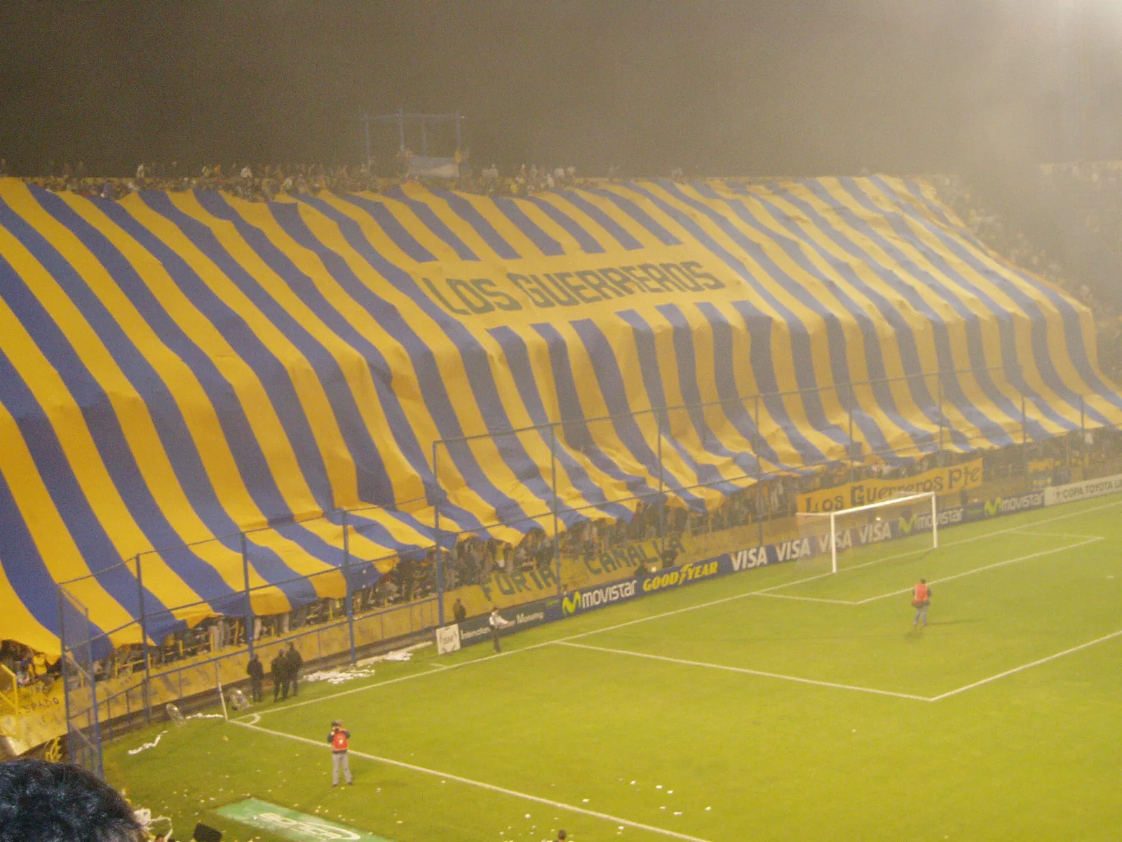 Bandera gigante desplegada en una tribuna popular de futbol argentino, simbolo de identidad de la hinchada