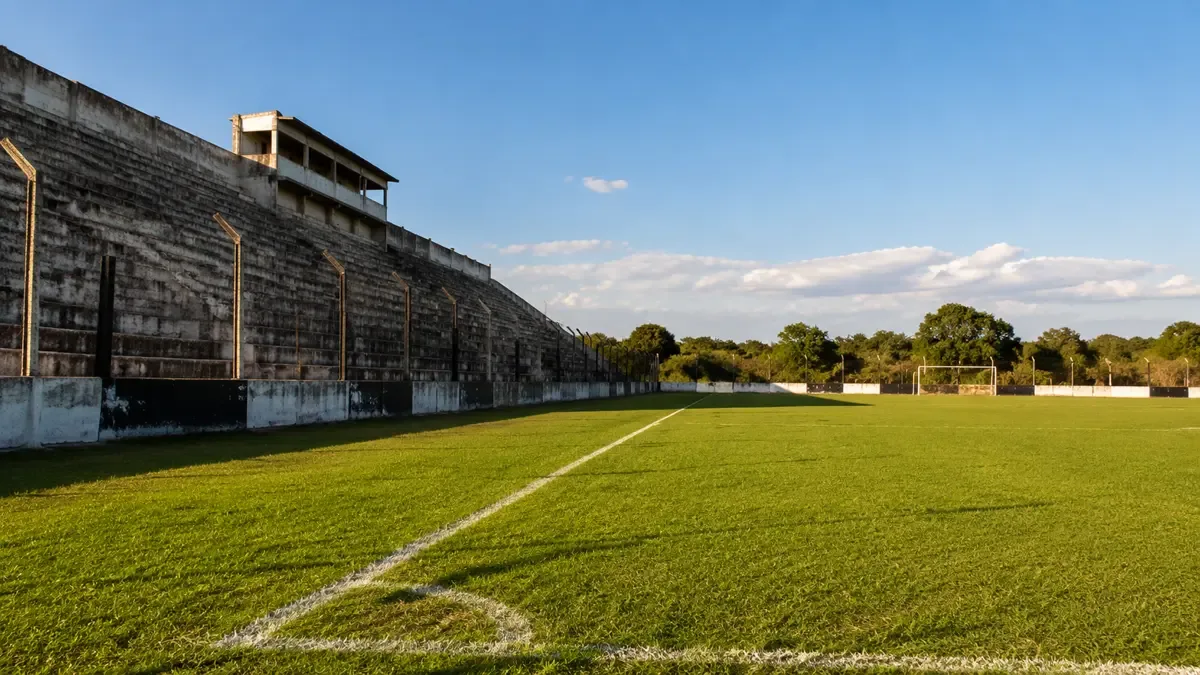 Tribuna de cemento vacía en un estadio de fútbol de ascenso por la tarde.